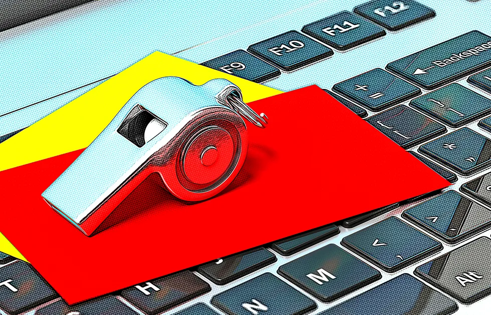 whistle, a red card, and a yellow card placed on a computer keyboard. Stock Photo